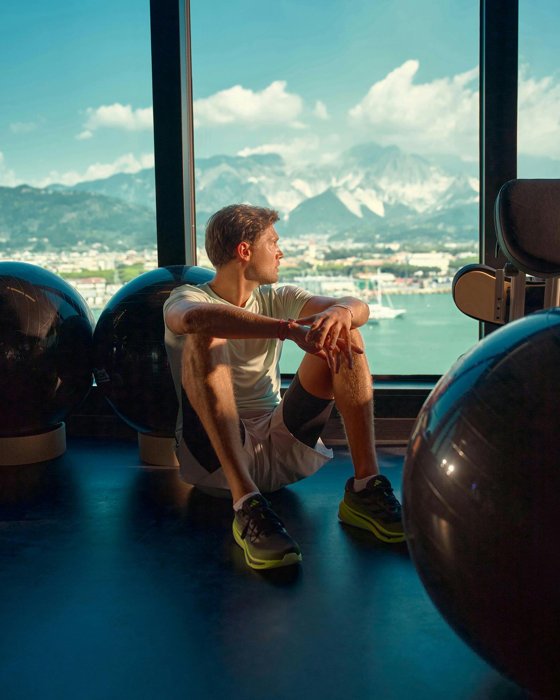 Guest at the onboard gym overlooking the water